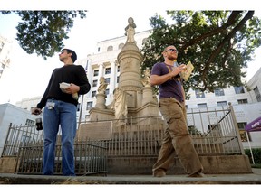 FILE - In this Nov. 4, 2011, file photo, Sean Bordelon, left, and Raphiel Heard, of Shreveport, pause after reading the inscription on the Confederate soldier's monument in front of the Caddo Parish Courthouse in Shreveport, La. A federal appeals court says a judge was right when he cleared the way to remove a Confederate monument at a north Louisiana courthouse. The 5th U.S. Circuit Court of Appeals on Monday, April 15, 2019, again turned back claims from the United Daughters of the Confederacy's Shreveport chapter. The group says it has a "private property interest" in the land where the statue stands in front of the Caddo Parish Courthouse. It also claims parish officials violated its rights to free speech and equal protection.