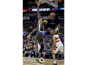 Golden State Warriors center DeMarcus Cousins (0) dunks over New Orleans Pelicans guard Kenrich Williams (34) in the first half of an NBA basketball game in New Orleans, Tuesday, April 9, 2019.