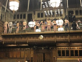 In this photo made available from the Twitter page of James Heappey MP, demonstrators protest in the public gallery in the House of Commons, London, Monday April 1, 2019. A dozen demonstrators have been arrested after stripping off in Britain's House of Commons to protest climate change. (James Heappey via AP)