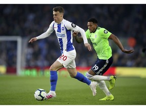 Brighton's Jamie Paterson, left, and Cardiff City's Nathaniel Mendez-Laing battle for the ball during the English Premier League soccer match at the AMEX Stadium, Brighton, England, Tuesday April 16, 2019.