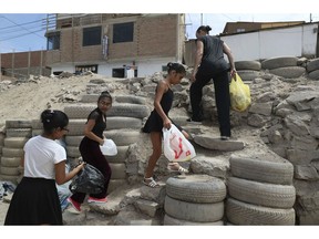 In this April 4, 2019 photo, Maria del Carmen Silva, a former professional dancer, and her ballet students, search and collect recycling plastic bottles for money, in the Chorrillos neighborhood, a poor part of Lima, Peru. If they can raise enough money for plane tickets. Silva hopes to take her students to Florida to participate in a dance competition later this year.