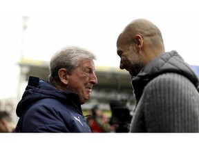 Crystal Palace manager Roy Hodgson, left, greets Manchester City manager Pep Guardiola before kick-off of their English Premier League soccer match at Selhurst Park, London, Sunday, April 14, 2019.