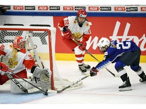 Goalkeeper Valeria Merkusheva, left, and Kendall Coyne Schofield of the U.S, right, battle for the puck during the IIHF Women's Ice Hockey World Championships Group A match between the USA and Russia in Espoo, Finland, Tuesday, April 9, 2019.