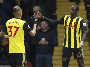 Watford's Abdoulaye Doucoure, right, celebrates scoring his side's first goal of the game with teammate Roberto Pereyra during their English Premier League soccer match against Fulham at Vicarage Road, Watford, England, Tuesday, April 2, 2019.