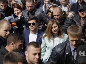 FILE - In this file photo dated Sunday, April 21, 2019, Ukrainian comedian and presidential candidate Volodymyr Zelenskiy, center left, and his wife Olena Zelenska, arrive at a polling station, during the second round of presidential elections in Kiev, Ukraine.  The Central Election Commission on Tuesday April 30, 2019, presented the official results of the April 21 vote, showing Zelenskiy beat incumbent President Petro Poroshenko by winning 73 per-cent of the vote.