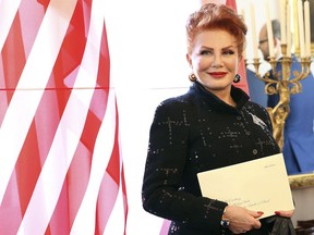 FILE - In this Sept. 6, 2018 file photo, Georgette Mosbacher stands next to an American flag after receiving her credentials as new United States ambassador to Poland in Warsaw. Ambassador Georgette Mosbacher wished Jews a happy Passover in Polish, and the reaction has been a wave of angry comments on Twitter. Mosbacher was accused of offending the country with her Passover tweet on Friday April 19, 2019, and was reminded she serves in a predominantly Roman Catholic country.