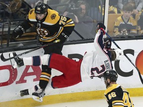 Columbus Blue Jackets right wing Oliver Bjorkstrand (28) is upended by Boston Bruins defenseman Connor Clifton (75) while chasing the puck during the first period of Game 2 of an NHL hockey second-round playoff series, Saturday, April 27, 2019, in Boston.