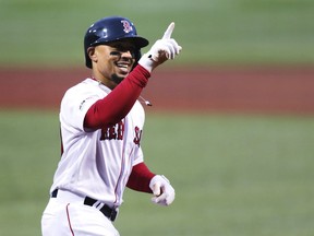 Boston Red Sox's Mookie Betts smiles as he crosses home plate on his solo home run off Oakland Athletics starting pitcher Aaron Brooks in the first inning of a baseball game at Fenway Park, Tuesday, April 30, 2019, in Boston.
