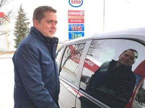 Conservative leader Andrew Scheer solemnly stares into the middle distance as he fuels up his vehicle one last time before the carbon tax.