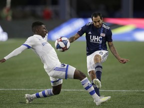 Montreal Impact's Clement Bayiha, left, attempts to block a pass by New England Revolution's Edgar Castillo (8) during the first half of an MLS soccer game, Wednesday, April 24, 2019, in Foxborough, Mass.