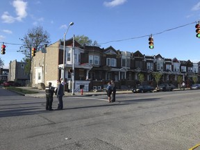 Authorities stand at Edmondson and Whitmore after multiple people were shot, Sunday, April 28, 2019, in Baltimore.