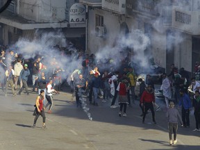 Teargas is used to disperse demonstrators during clashes with police in Algiers, Algeria, March 29, 2019. Algerians taking to the streets for their sixth straight Friday of protests aren't just angry at their ailing president, they want to bring down the entire political system that has sustained him.