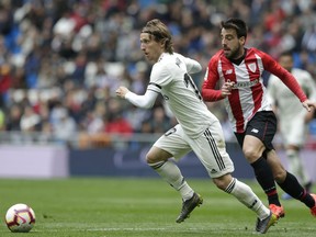 Real Madrid's Luka Modric, left, duels for the ball with Athletic Bilbao's Benat Etxebarria during a Spanish La Liga soccer match between Real Madrid and Athletic Bilbao at the Santiago Bernabeu stadium in Madrid, Spain, Sunday, April 21, 2019.