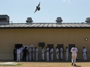 FILE - In this June 18, 2015, file photo, prisoners stand in a crowded lunch line during a prison tour at Elmore Correctional Facility in Elmore, Ala. The Justice Department has determined that Alabama's prisons are violating the Constitution by failing to protect inmates from violence and sexual abuse and by housing them in unsafe and overcrowded facilities, according to a scathing report Wednesday, April 3, 2019, that described the problems as "severe" and "systemic."
