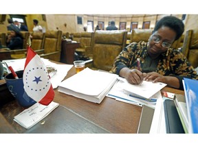 FILE- In this Feb. 17, 2016 file photo, a new conceptualized Mississippi state flag sits on the desk of Rep. Kathy Sykes, D-Jackson, at the Capitol in Jackson, Miss. The flag was designed by Laurin Stennis, the granddaughter of the late U.S. Sen. John Stennis, D-Miss. Mississippi residents who want a state flag without the Confederate battle emblem now have an alternative at least for their license plates. Gov. Phil Bryant on Tuesday, April 17, 2019, signed a bill authorizing designs for several new specialty license plates