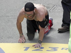 Micah Herndon crawls to the finish line in the 123rd Boston Marathon in a time of three hours and 38 minutes.