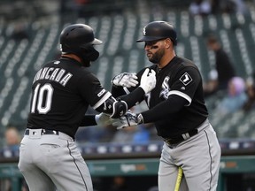Chicago White Sox's Yoan Moncada (10) celebrates his solo home run with Yonder Alonso, against the Detroit Tigers during the first inning of a baseball game in Detroit, Friday, April 19, 2019.