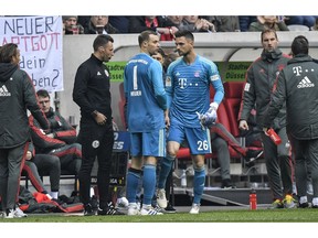 Bayern goalkeeper Manuel Neuer, left, leaves the pitch injured for Bayern goalkeeper Sven Ulreich, right, during the German Bundesliga soccer match between Fortuna Duesseldorf and Bayern Munich in Duesseldorf, Germany, Sunday April 14, 2019.