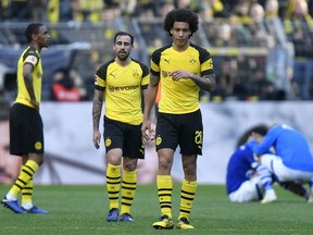 Dortmund's Axel Witsel and Dortmund's Paco Alcacer leave the pitch disappointed after losing the German Bundesliga soccer match between Borussia Dortmund and FC Schalke 04 in Dortmund, Germany, Saturday, April 27, 2019. Dortmund was defeated in the Derby by Schalke with 2-4.