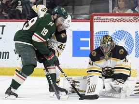 Boston Bruins' goaltender Jaroslav Halak (41), of Slovakia, stops a shot by Minnesota Wild's Luke Kunin (19) as Boston Bruins' Matt Grzelcyk (48) helps defend during the first period of an NHL hockey game Thursday, April 4, 2019, in St. Paul, Minn.