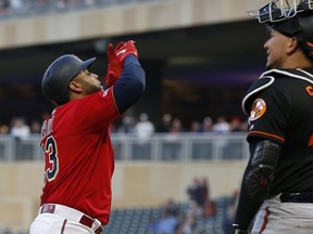 Minnesota Twins' Nelson Cruz, left, celebrates his solo home run off Baltimore Orioles' pitcher Alex Cobb as he passes Orioles catcher Jesus Sucre in the first inning of a baseball game Friday, April 26, 2019, in Minneapolis.