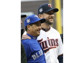 Toronto Blue Jays manager Charlie Montoya, left, and Minnesota Twins manager Rocco Baldelli pose with umpires before a baseball game Monday, April 15, 2019, in Minneapolis. The two friends were on Tampa Bay's coaching staff last season and spent several years in the Rays organization together. Both got hired as first-time managers this season.