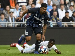 Minnesota United forward Abu Danladi, bottom, falls to the turf as Los Angeles Galaxy midfielder Jonathan dos Santos dribbles the ball in the first half of an MLS soccer game, Wednesday, April 24, 2019, in St. Paul, Minn.