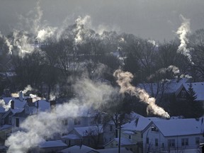 FILE- In this Wednesday Jan. 30, 2019, file photo smoke rises from the chimneys of homes in St. Paul, Minn. Americans burned a record amount of energy in 2018, with a 10% jump in consumption from booming natural gas helping to lead the way, the U.S. Energy Information Administration says. Overall consumption of all kinds of fuels rose 4% year on year, the largest such increase in eight years, a report this week from the agency said. Fossil fuels in all accounted for 80% of Americans' energy use.