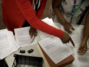 City workers to look through a petition with 2,857 signatures, after citizens opposed to changing the name of the Paseo Boulevard to Dr. Martin Luther King Jr. Boulevard delivered it to the city clerk Friday, April 26, 2019, in Kansas City, Mo. More than 50 years after the King was assassinated, the question of how to honor him divides Kansas City residents.