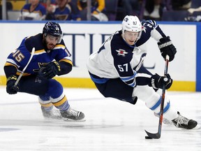Winnipeg Jets' Tyler Myers (57) handles the puck as St. Louis Blues' Robby Fabbri (15)pursues during the second period in Game 6 of an NHL first-round hockey playoff series, Saturday, April 20, 2019, in St. Louis.