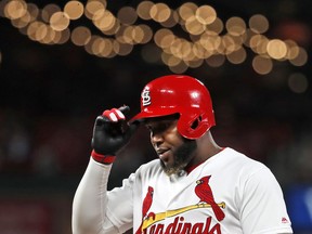 St. Louis Cardinals' Marcell Ozuna removes his helmet after popping out to end the seventh inning of a baseball game against the Cincinnati Reds Friday, April 26, 2019, in St. Louis.
