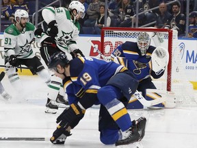St. Louis Blues' Jay Bouwmeester (19) lays down to help defend against a shot blocked by goaltender Jordan Binnington (50) and Dallas Stars' Tyler Seguin (91) and Mats Zuccarello, second from left, look on during the third period in Game 1 of an NHL second-round hockey playoff series Thursday, April 25, 2019, in St. Louis.