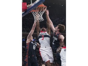 Washington Wizards guard Bradley Beal (3) goes to the basket against New York Knicks' Mario Hezonja (8) and Luke Kornet (2) during the first half of an NBA basketball game, Sunday, April 7, 2019, at Madison Square Garden in New York.