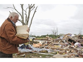 Robert Scott looks through a family Bible that he pulled out of the rubble Sunday, April 14, 2019, from his Seely Drive home outside of Hamilton, Miss., after an apparent tornado touched down Saturday night.