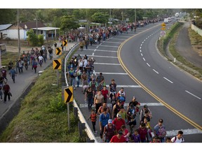 CORRECTS LOCATION - Central American migrants, part of the caravan hoping to reach the U.S. border, walk on the shoulder of a road in Frontera Hidalgo, Mexico, Friday, April 12, 2019. The group pushed past police guarding the bridge and joined a larger group of about 2,000 migrants who are walking toward Tapachula, the latest caravan to enter Mexico.