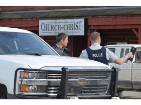 RCMP officers talk behind a barricade in front of the Salmon Arm Church of Christ in Salmon Arm, B.C. on Sunday, April 14, 2019. One person is in custody and one person was airlifted to hospital after a possible shooting in Salmon Arm, B.C. Salmon Arm RCMP say they are responding to a serious incident, which they say is a possible shooting, in the city, about 100 kilometres north of Kelowna.THE CANADIAN PRESS/Murray Mitchell