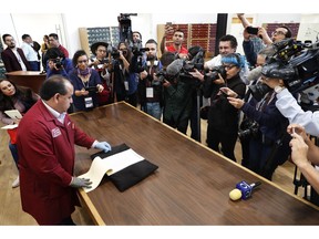 A National Archive employees shows old intelligence documents drawn up by spies in 1979 and 1980 from the now-extinct Federal Security Department, at a media presentation in Mexico City, Tuesday, April 16, 2019. Mexico's domestic intelligence agency was once so paranoid it even spied on members of the former ruling party. One such member was current President Andres Manuel López Obrador, who previously belonged to the Institutional Revolutionary Party.