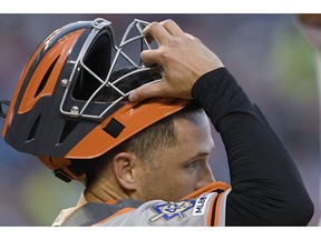 San Francisco Giants catcher Buster Posey wears a No. 42 patch on his sleeve in honor of Jackie Robinson Day, during the first inning of the team's baseball game against the Washington Nationals, Tuesday, April 16, 2019, in Washington.