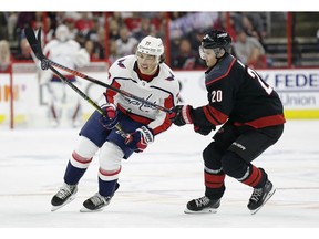 Carolina Hurricanes' Sebastian Aho (20), of Finland, and Washington Capitals' T.J. Oshie (77) chase the puck during the first period of Game 3 of an NHL hockey first-round playoff series in Raleigh, N.C., Monday, April 15, 2019.