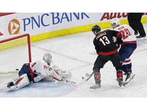 Carolina Hurricanes' Warren Foegele (13) scores against Washington Capitals goalie Braden Holtby (70) while Capitals' Lars Eller (20) defends during the second period of Game 3 of an NHL hockey first-round playoff series in Raleigh, N.C., Monday, April 15, 2019.