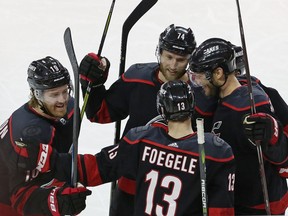 Carolina Hurricanes' Dougie Hamilton (19), Warren Foegele (13), Jordan Staal, right, and Jaccob Slavin (74) celebrate Hamilton's goal against the Washington Capitals during the third period of Game 3 of an NHL hockey first-round playoff series in Raleigh, N.C., Monday, April 15, 2019. Carolina won 5-0.