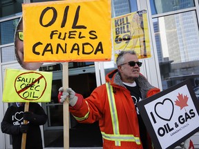 Oil and gas supporters picket outside the National Energy Board during the release of the board's reconsideration report on marine shipping related to the Trans Mountain expansion project, in Calgary on Feb. 22, 2019.