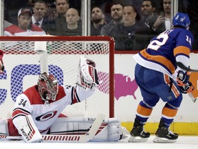 Carolina Hurricanes goaltender Petr Mrazek (34), of the Czech Republic, makes a glove save against New York Islanders right wing Josh Bailey (12) during the first period of Game 1 of an NHL hockey second-round playoff series, Friday, April 26, 2019, in New York.