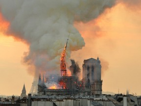 In this image made available on Tuesday April 16, 2019 flames and smoke rise from the blaze as the spire starts to topple on Notre Dame cathedral in Paris, Monday, April 15, 2019.