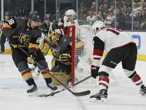 Vegas Golden Knights center Paul Stastny, left, knocks the puck away from Arizona Coyotes center Christian Dvorak during the first period of an NHL hockey game Thursday, April 4, 2019, in Las Vegas.