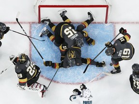 Vegas Golden Knights defenseman Jon Merrill (15) and defenseman Colin Miller (6) help keep the puck out of the net against the San Jose Sharks during the first overtime in Game 6 of a first-round NHL hockey playoff series Sunday, April 21, 2019, in Las Vegas.