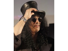 FILE - In this April 22, 2010 file photo, former Guns N' Roses guitarist Slash greets fans during an event in Tokyo, Japan.  The former wife of Guns N' Roses guitarist Slash is selling off exotic and erotic items from their 14 years of marriage. Julien's Auctions on Thursday, April 3, 2019  announced the collection from Slash and Perla Hudson's Beverly Hills estate will be part of next month's Music Icons auction.