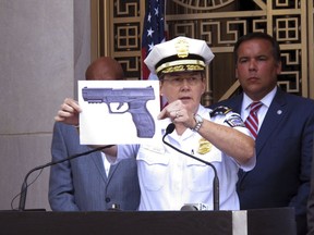 FILE - In this Sept. 15, 2016 file photo, Columbus Police Chief Kim Jacobs holds up a photo showing the type of BB gun that police say a 13-year-old Tyre King pulled from his waistband just before he was shot and killed by police investigating an armed robbery report in Columbus, Ohio.  Four teenagers who were with King before he was fatally shot by a white police officer have been added as third-party defendants in a civil rights lawsuit over his death, even though his family doesn't believe the teens should be held financially responsible. The teens were added to the federal case over the death of King at the request of the city of Columbus, meaning they could be on the hook if the city or the officer is found liable for damages in the lawsuit.