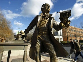 FILE - In this Tuesday, Dec 14, 2010 file photo, a statue of George Mason stands in the heart of George Mason University's Fairfax campus in Fairfax, Va. Following an uproar over revelations that George Mason University, Virginia's largest university allowed the conservative Charles Koch Foundation to give input in some personnel decisions, the school is tightening its rules governing agreements with donors to ensure they don't infringe on academic freedom. The new rules implement recommendations made in October after a committee reviewed hundreds of agreements and found nearly 30 containing potentially problematic provisions.