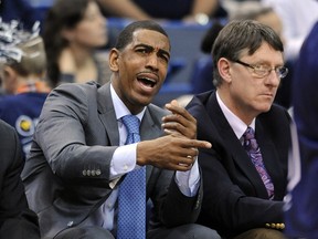 FILE - In this Dec. 6, 2013, file photo, then-Connecticut head coach Kevin Ollie signals to his team as associate head coach Glenn Miller looks on during the first half of Connecticut's 95-68 victory over Maine in an NCAA college basketball game, in Hartford, Conn. Former UConn basketball coach Kevin Ollie has filed a lawsuit against former assistant Glenn Miller, contending Miller slandered him in comments to the NCAA. Miller told the governing body he had learned about an alleged $30,000 payment Ollie made to the mother of a recruit while at UConn. Ollie's lawsuit, filed Monday, April 29, 2019, in Connecticut Superior Court, says that accusation was false and damaged his reputation.